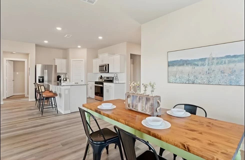 Bright open-plan kitchen and dining area with a wooden table
