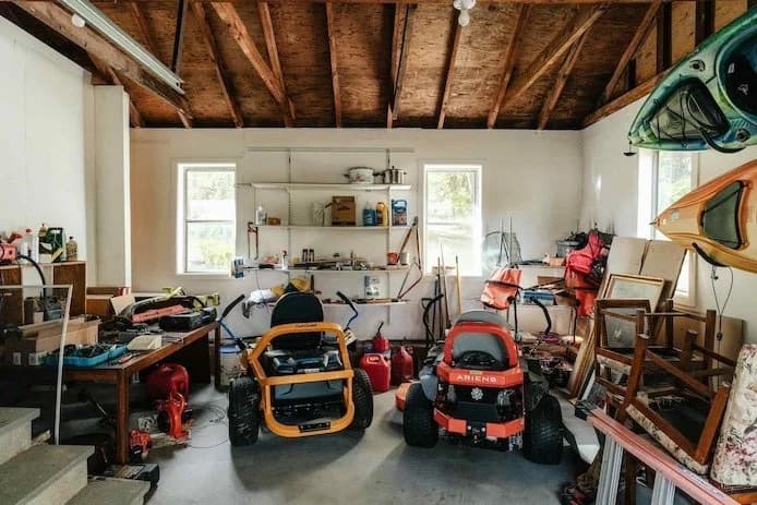 Cluttered garage full of equipment and items awaiting cleanout